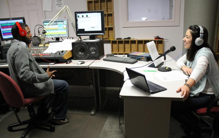 Alumna Grisel Barajas (right) and Darin Lander (left) interact with the community on the air Tuesday.
