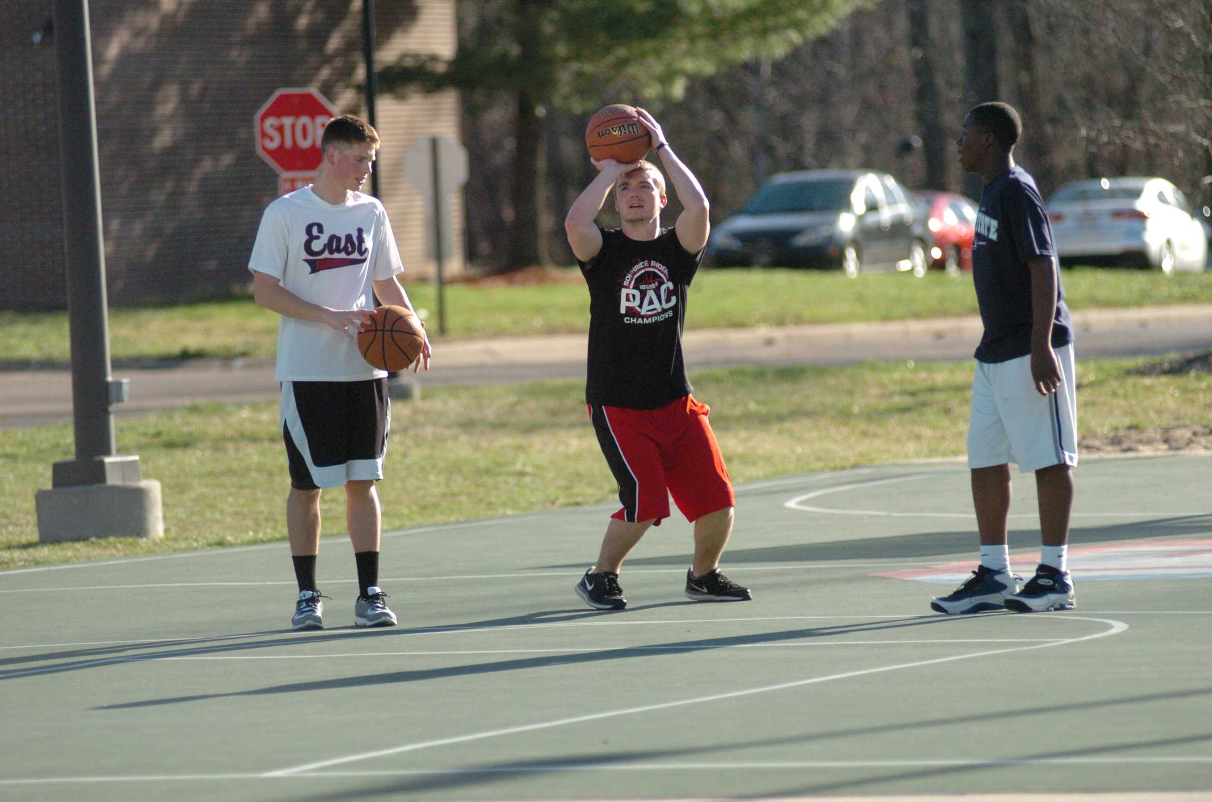 Sophomore engineering major Ian Mathies and sophomore elementary education major Nicholas Herron play basketball outside of the C-store with a friend's brother, Corey Kirkland, 13 (left to right). Both students live in the Marshall apartment complex on campus. Photo by Bobby Shipman/The Shield