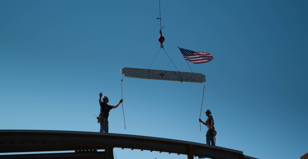 Workers guide the final beam to the Teaching Theatre at the topping-off ceremony Thursday.  Photo by NIGEL MEYER/The Shield
