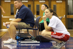 Assistant women’s basketball coach and student of the new sports management program Stephanie Gelhlhausen watches as players run sprints at their first basketball practice on Thursday